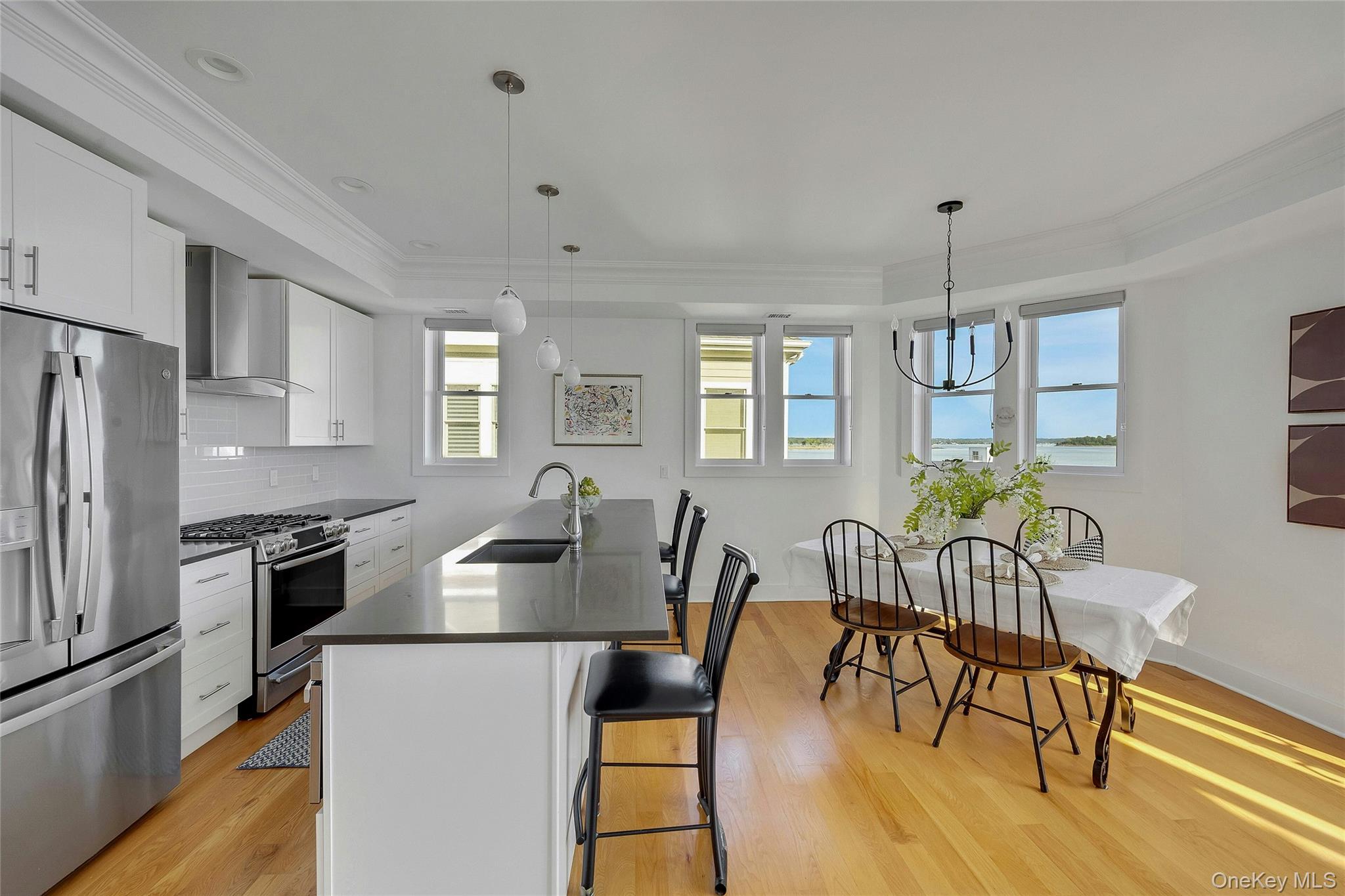 39 Island Point Bronx, NY 10464 - Photo 8 of 37 a kitchen with granite countertop a dining table chairs refrigerator and wooden floor