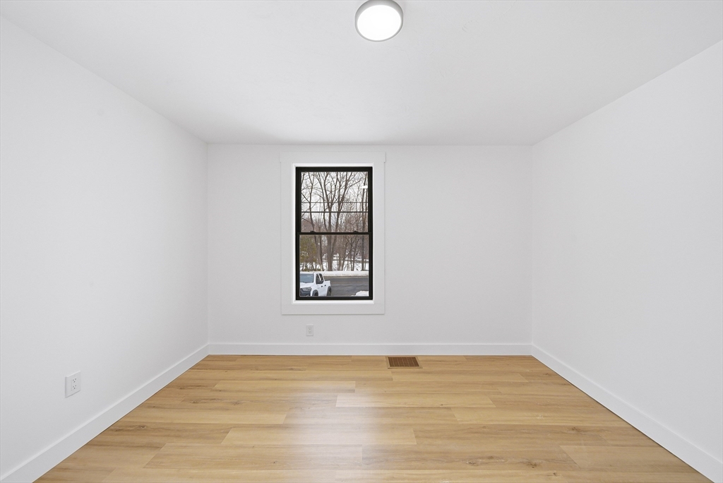 26 Rivulet Street Uxbridge, MA 01569 - Photo 22 of 41 a view of an empty room with wooden floor and a window