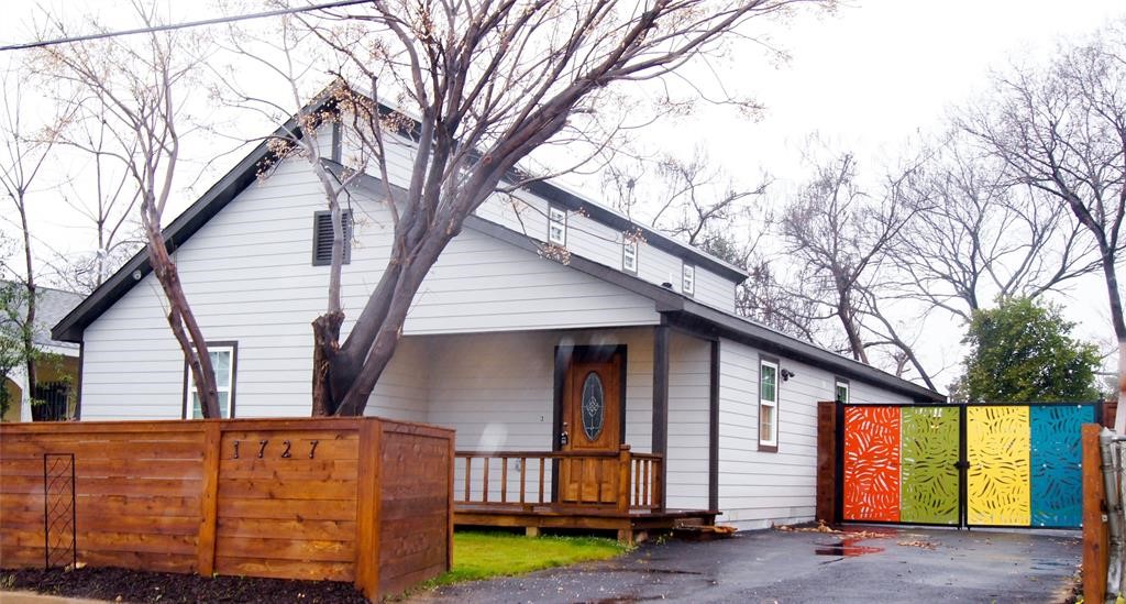 a view of a house with a large tree and wooden fence