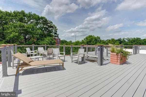 a view of roof deck with table and chairs and wooden floor