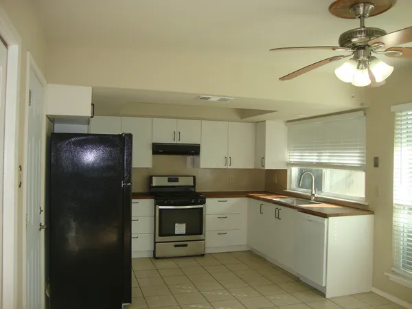a kitchen with a sink stainless steel appliances and chandelier