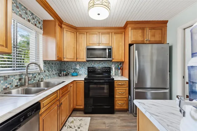 a kitchen with stainless steel appliances granite countertop a refrigerator stove and sink