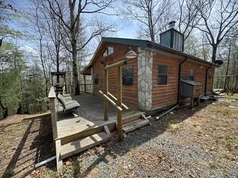 a view of backyard with wooden fence and large trees