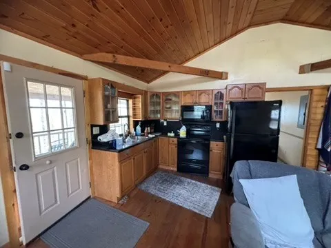 a kitchen with stainless steel appliances kitchen island granite countertop a table chairs and a refrigerator
