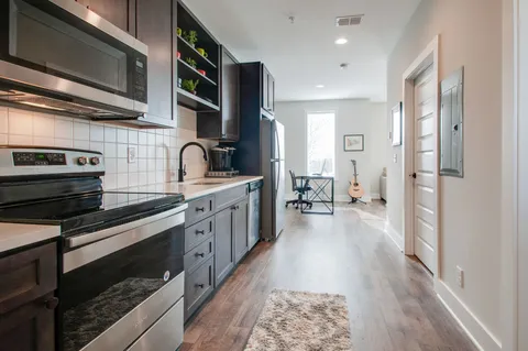a kitchen with stainless steel appliances a stove a sink and a refrigerator
