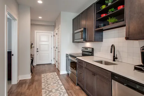 a kitchen with stainless steel appliances granite countertop a sink stove and cabinets