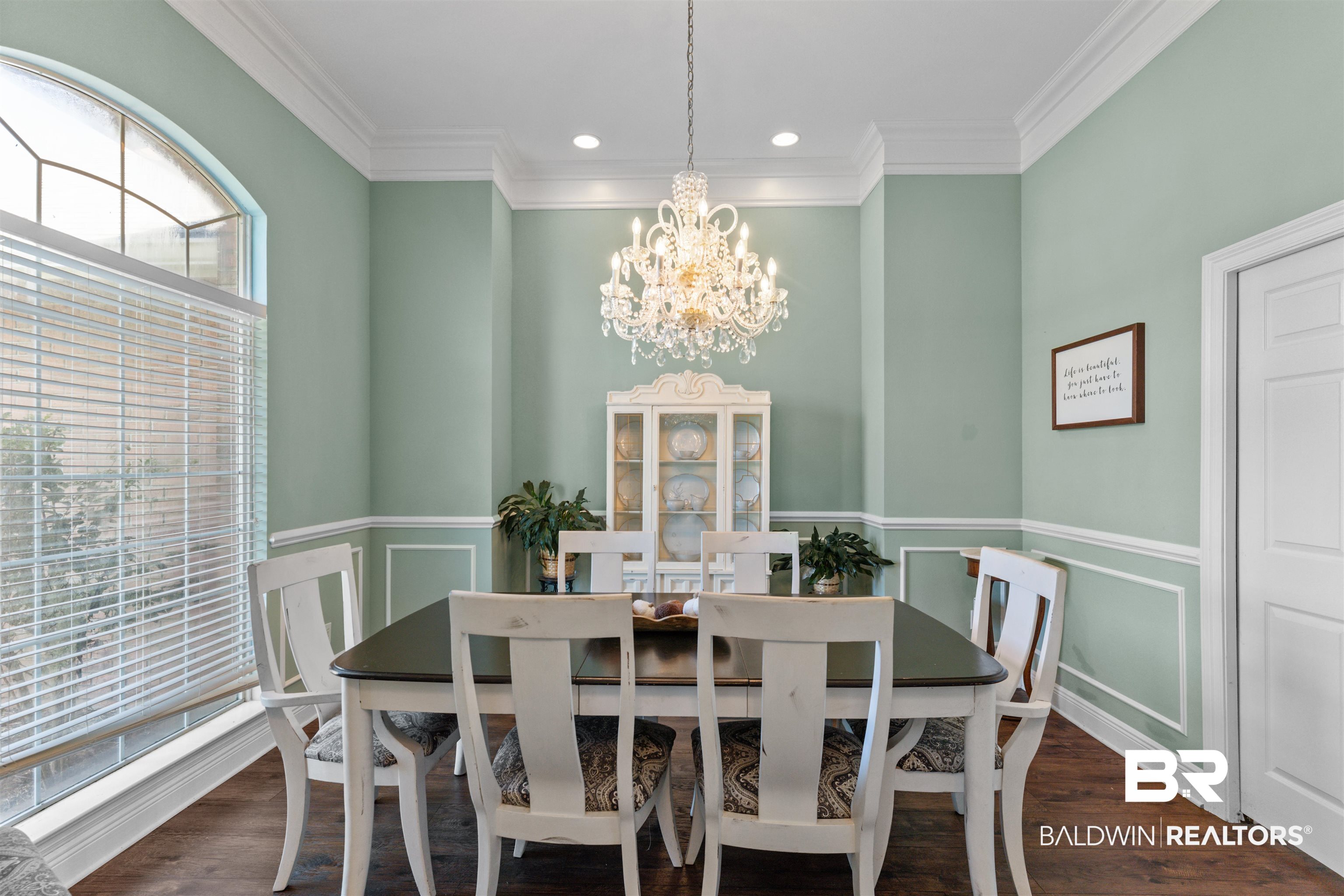 12664 Hunters Chase Foley, AL 36535 - Photo 15 of 62 Dining room with a decorative wall, dark wood-style floors, crown molding, a chandelier, and a wainscoted wall