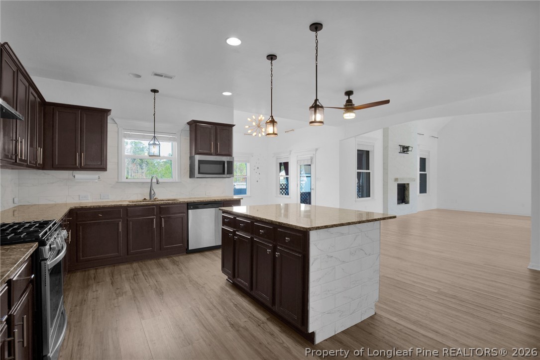 2145 Harrington Road Fayetteville, NC 28306 - Photo 20 of 50 a large kitchen with stainless steel appliances granite countertop a stove a sink dishwasher a refrigerator and a oven with wooden floor