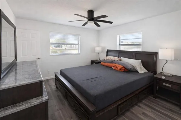 a bedroom with a bed and a flat tv screen on the dresser