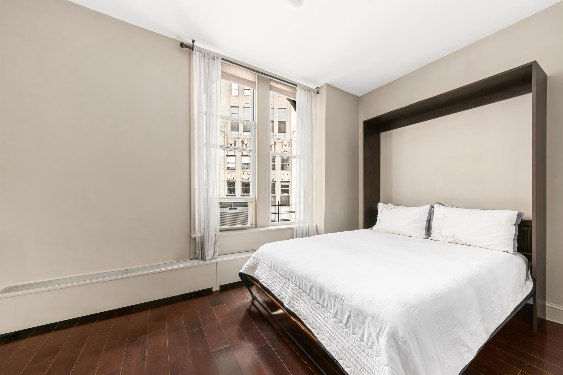 3 Hanover Square, Unit 22A Manhattan, NY 10004 - Photo 15 of 23 a bedroom with a bed and a window