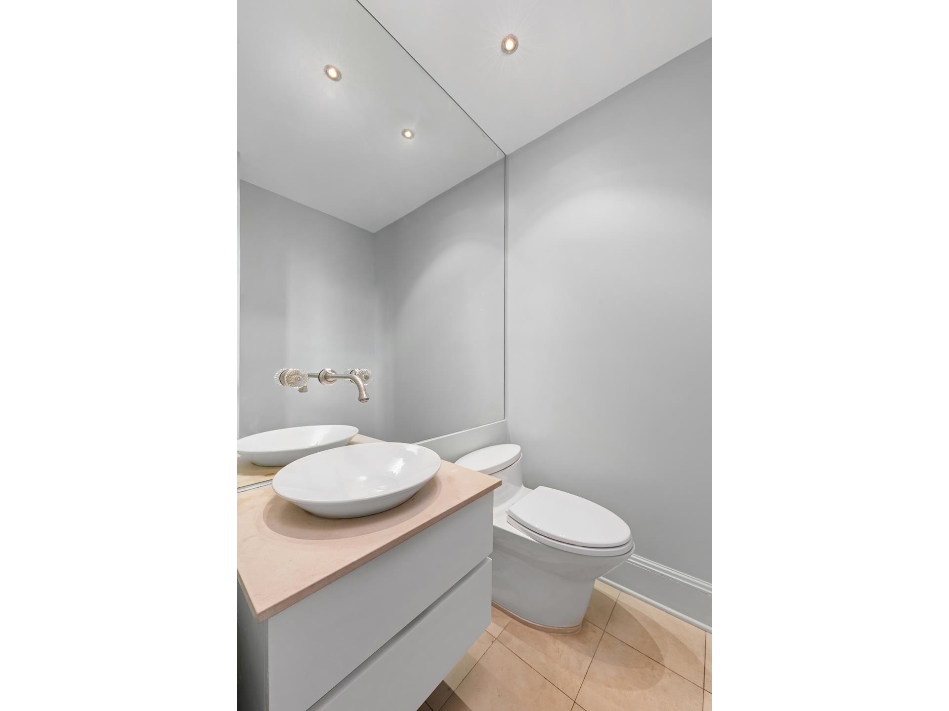 3 Hanover Square, Unit 22A Manhattan, NY 10004 - Photo 19 of 23 a bathroom with a granite countertop toilet a sink and a mirror