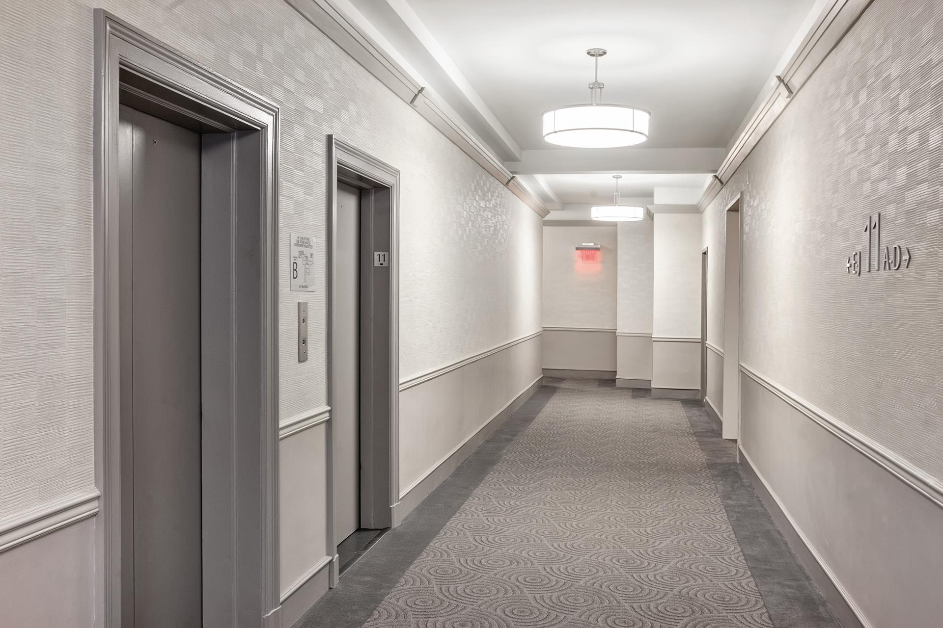 3 Hanover Square, Unit 22A Manhattan, NY 10004 - Photo 22 of 23 a view of a hallway with windows and chandelier