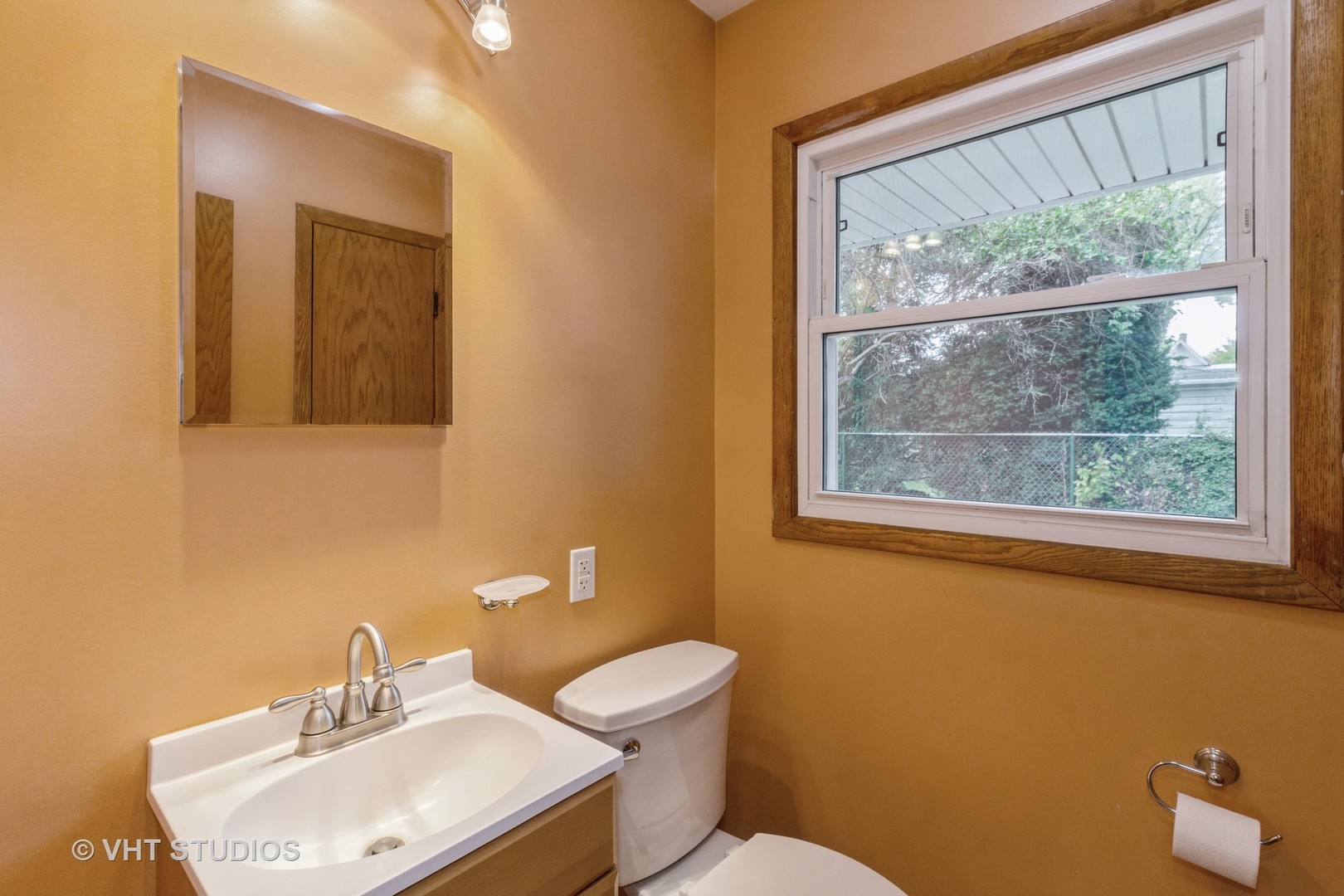 211 East Ottawa Street Sycamore, IL 60178 - Photo 14 of 33 a bathroom with a toilet a sink a mirror and a window