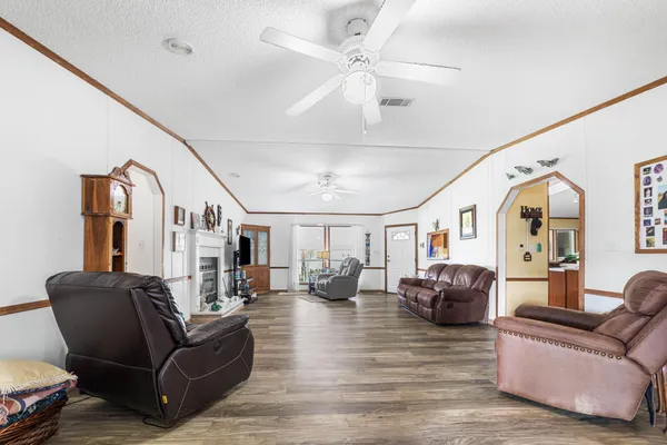 a living room with furniture flat screen tv and a large window