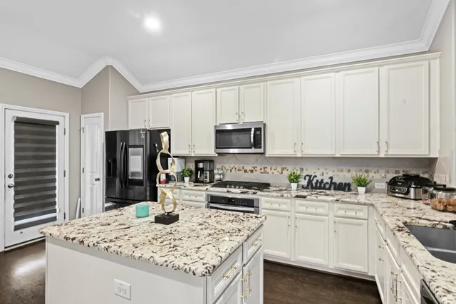 a kitchen with appliances a sink and cabinets
