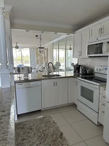 a kitchen with stainless steel appliances granite countertop a sink a stove and cabinets
