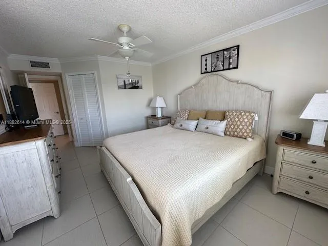 a bedroom with a bed and a flat tv screen on dresser