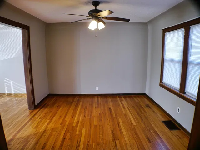 a view of room with window ceiling fan and hardwood floor