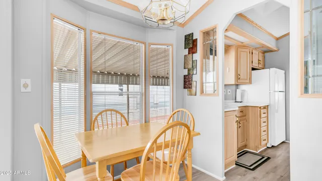 a dining room with furniture a chandelier and wooden floor