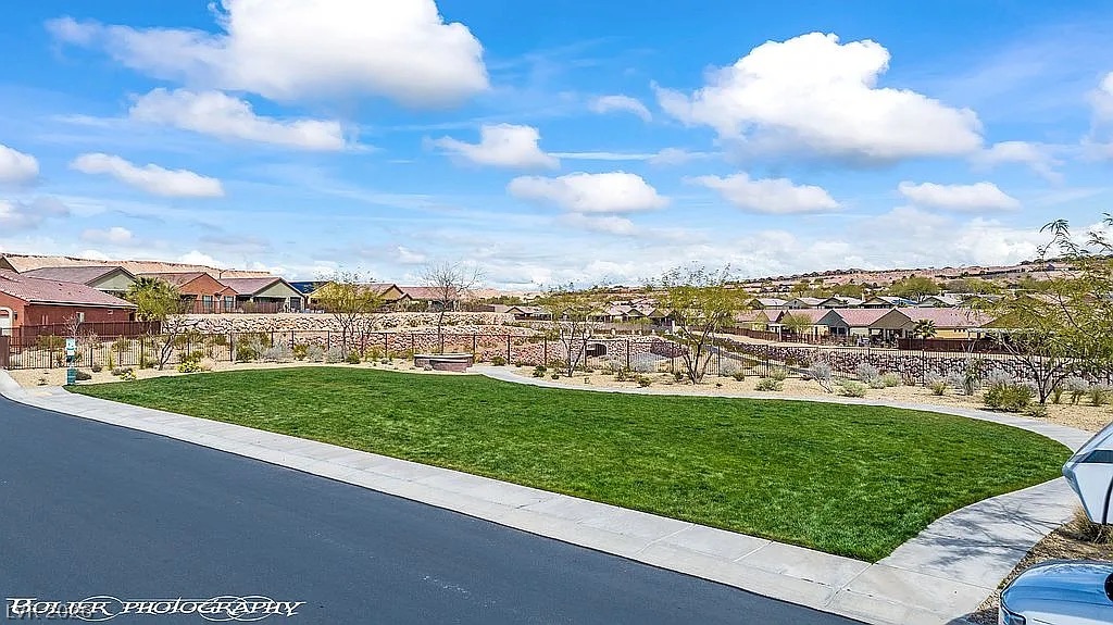 1304 Cottage Ridge Mesquite, NV 89034 - Photo 46 of 52 Green space abounds, bordered by modern homes under a vibrant sky, offering community park-like amenities.