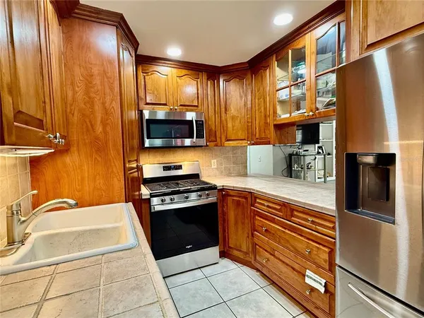 a kitchen with stainless steel appliances granite countertop a refrigerator and a stove top oven