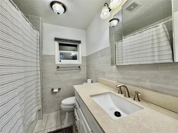 a bathroom with a sink a toilet and mirror