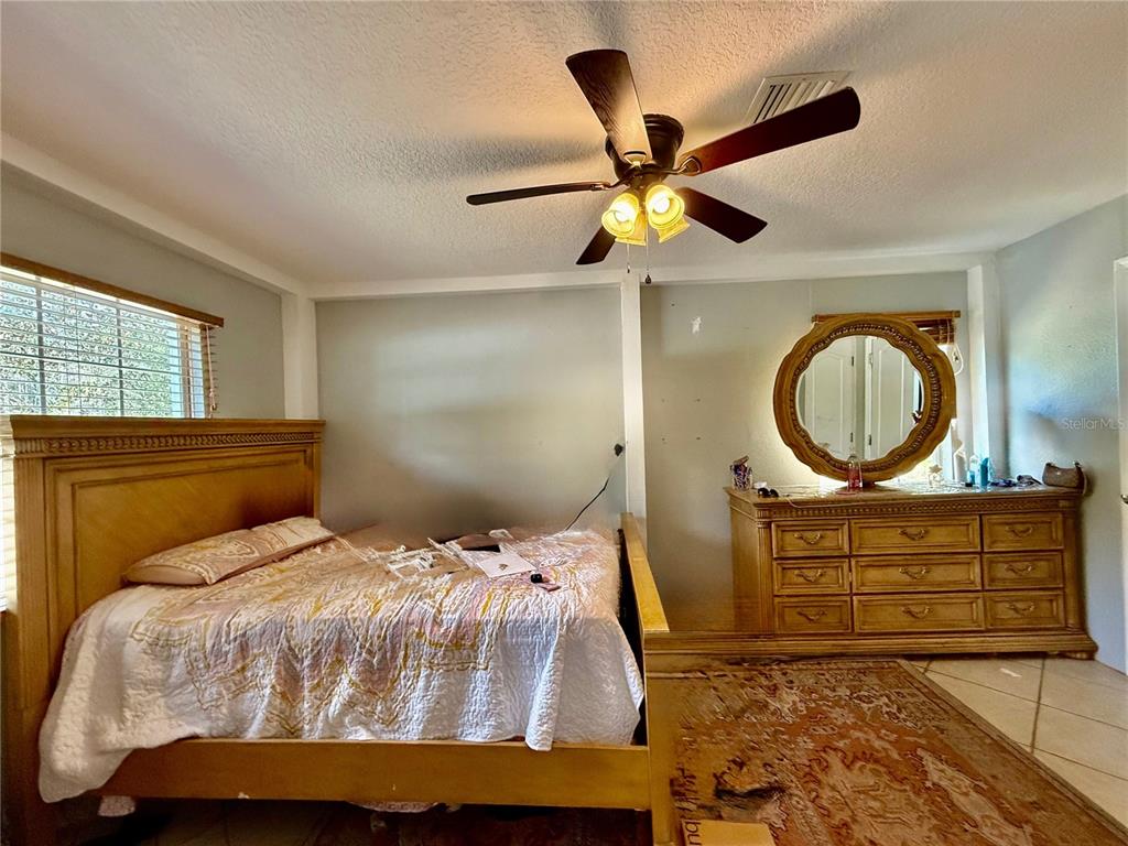 1363 Emporia Road Pierson, FL 32180 - Photo 19 of 27 a bedroom with a bed a mirror and a window