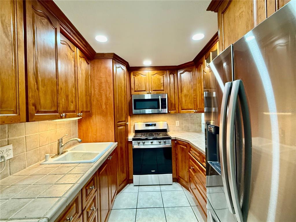 1363 Emporia Road Pierson, FL 32180 - Photo 9 of 27 a kitchen with stainless steel appliances granite countertop a refrigerator a sink and wooden cabinets