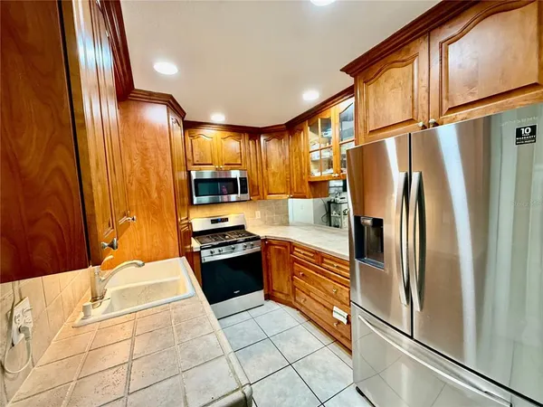 a kitchen with stainless steel appliances granite countertop a refrigerator a stove a sink and dishwasher