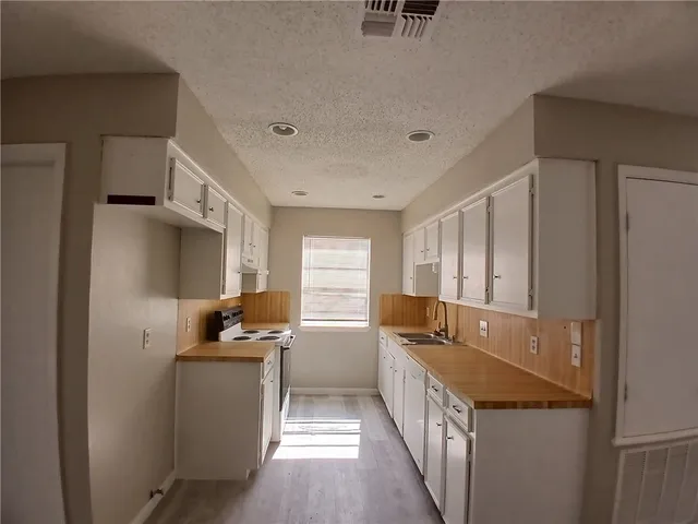 a kitchen that has a sink and a stove in it