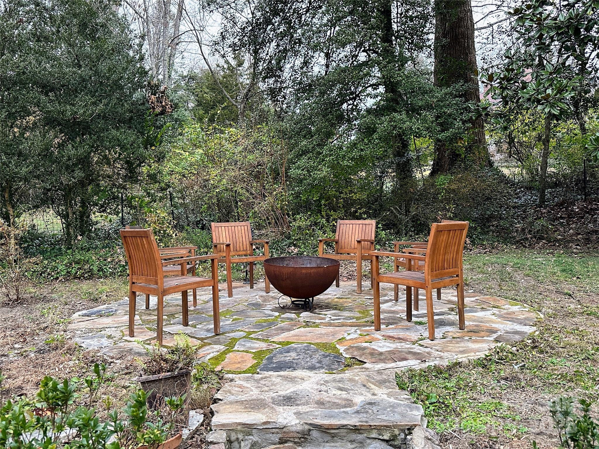 105 Melrose Lane Tryon, NC 28782 - Photo 26 of 35 a view of a backyard with table and chairs potted plants and large tree