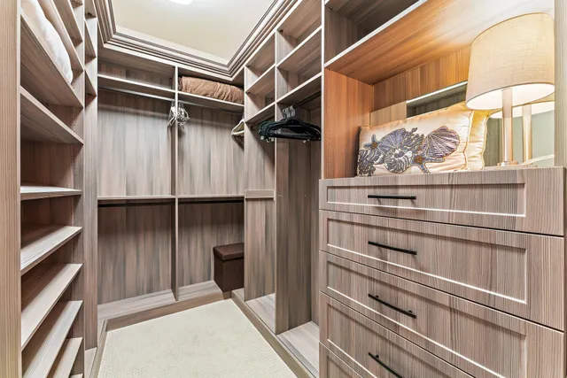 a bedroom with a large bed and a flat tv screen on dresser