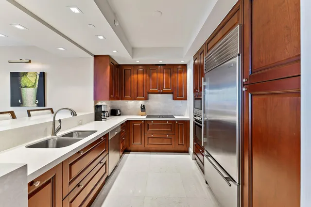 a kitchen with granite countertop a refrigerator and a sink