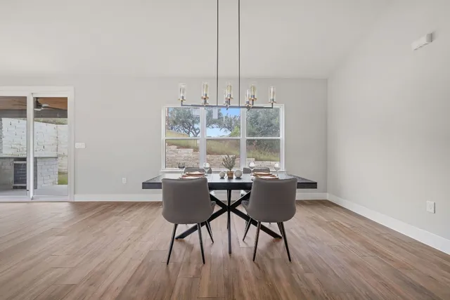 a dining room with furniture a chandelier and wooden floor