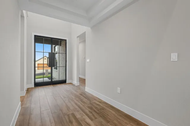 an empty room with wooden floor and a window