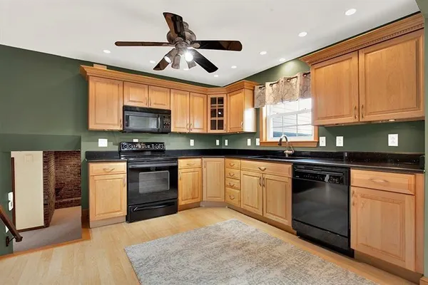 a kitchen with granite countertop a stove sink microwave and cabinets