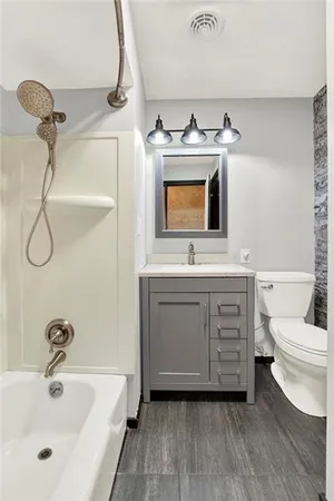 a bathroom with a double vanity sink mirror and toilet