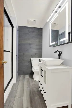 a bathroom with a sink a toilet and mirror