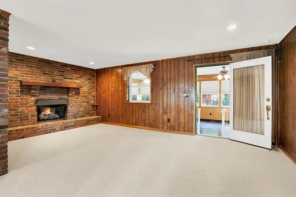 an empty room with windows and fireplace