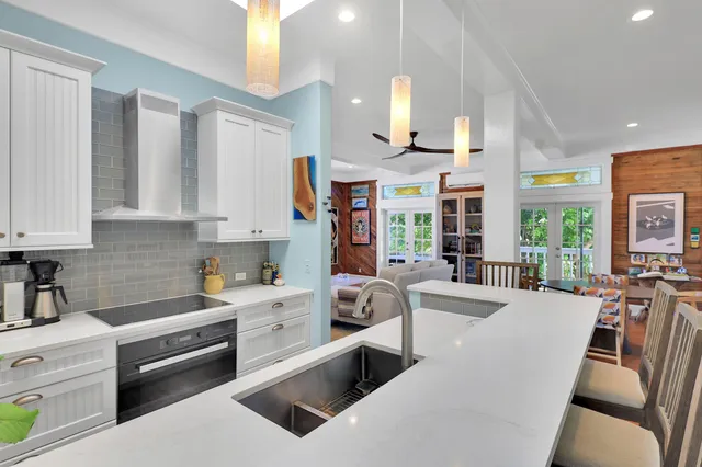a large white kitchen with stainless steel appliances