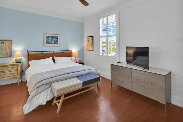 a bedroom with a bed and a flat screen tv