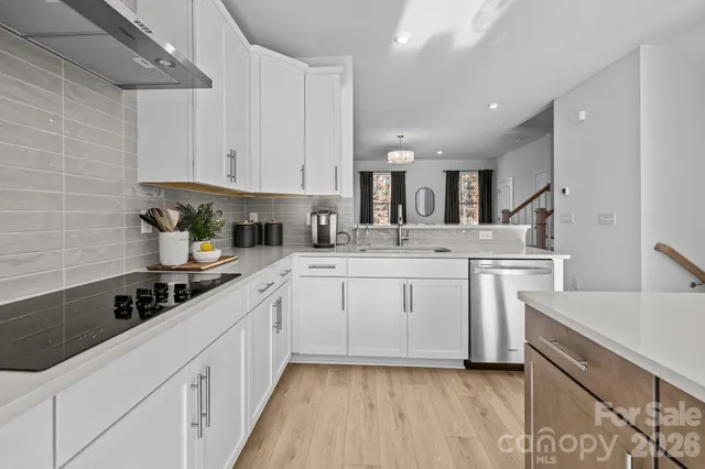 a kitchen with white cabinets stainless steel appliances a sink and a counter top space