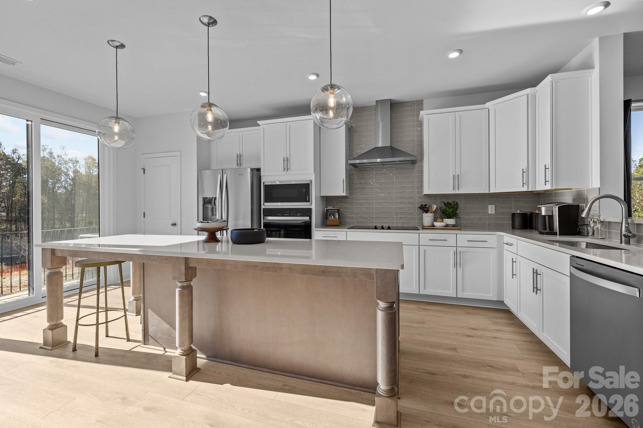 3025 Rozzelles Ferry Road Charlotte, NC 28208 - Photo 7 of 23 a kitchen with stainless steel appliances kitchen island granite countertop a stove a sink a refrigerator a center island a stove and white cabinets with wooden floor