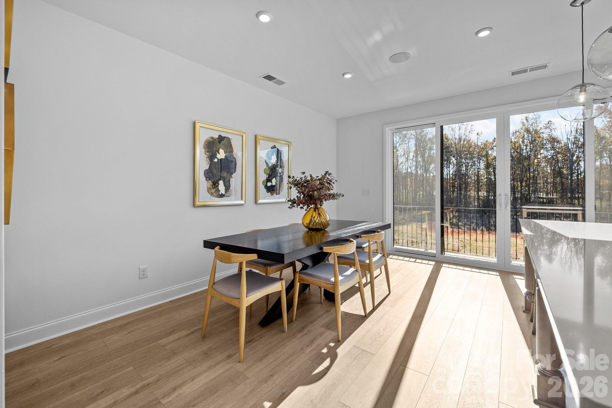 3025 Rozzelles Ferry Road Charlotte, NC 28208 - Photo 8 of 26 a dining room with wooden floor and a floor to ceiling window