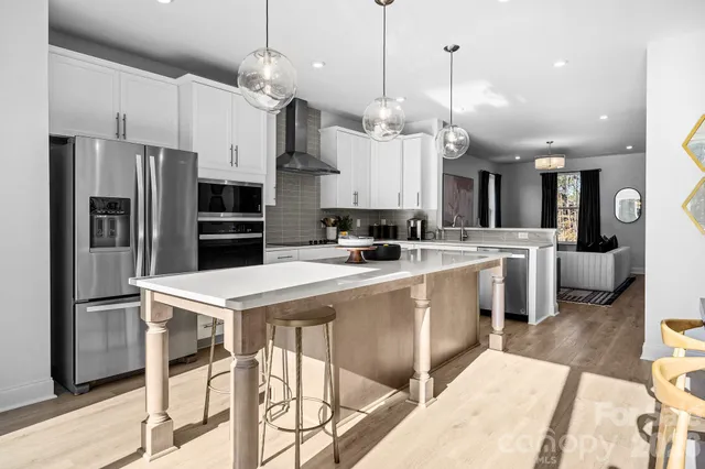 a kitchen with stainless steel appliances kitchen island a refrigerator and a stove top oven