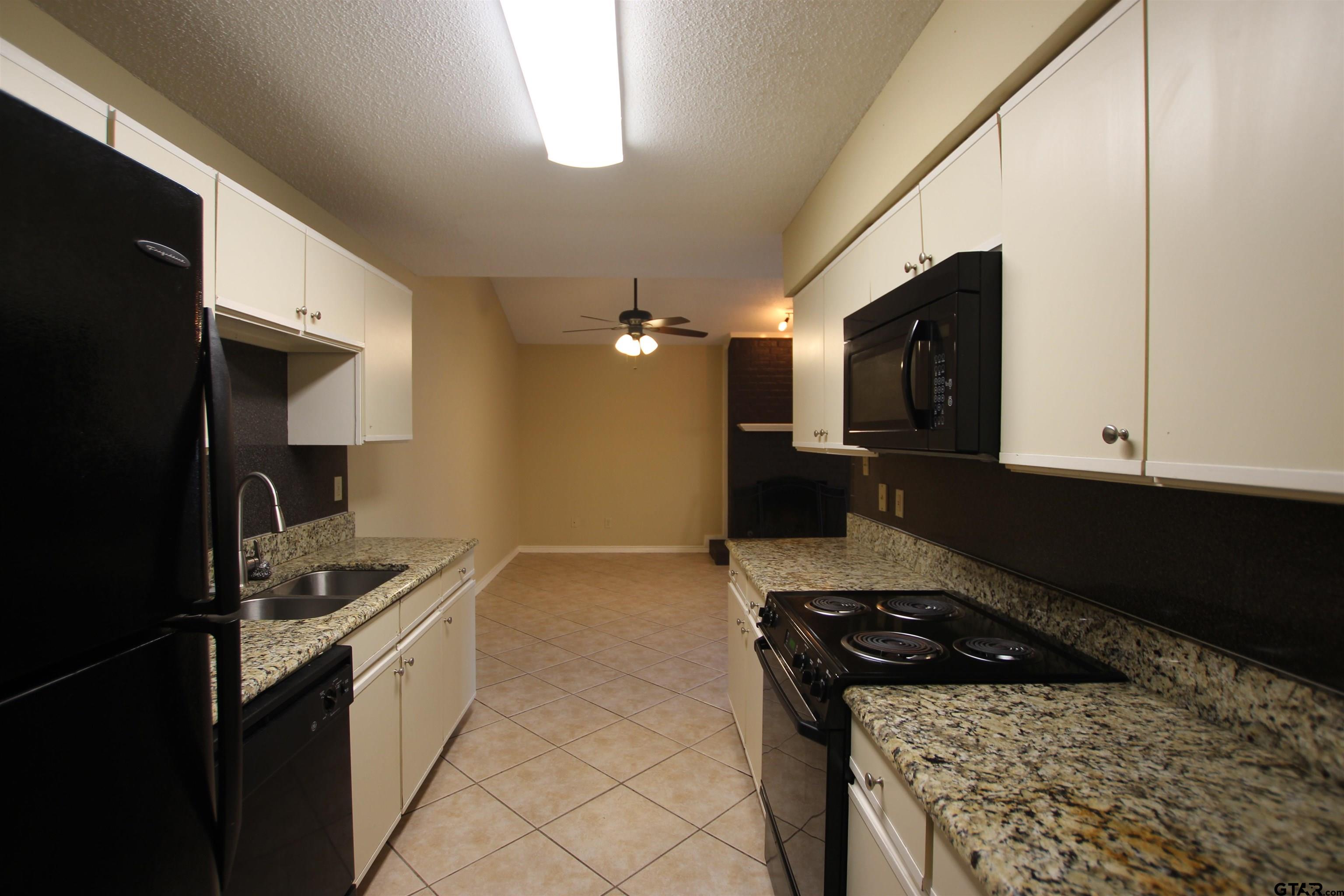 5875 Creekside Circle Tyler, TX 75703 - Photo 13 of 32 a kitchen that has a sink wooden cabinets and stainless steel appliances