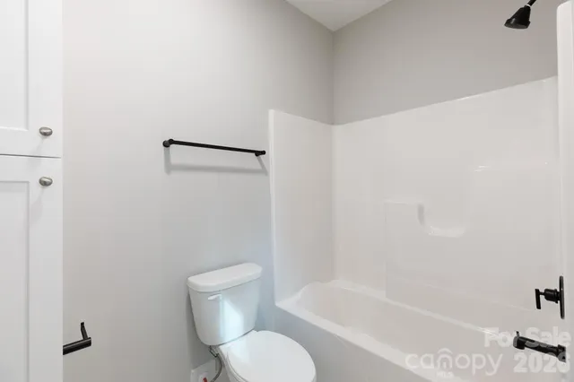 a white toilet sitting next to a bath tub