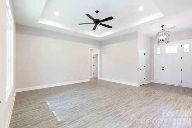 an empty room with wooden floor and ceiling fan