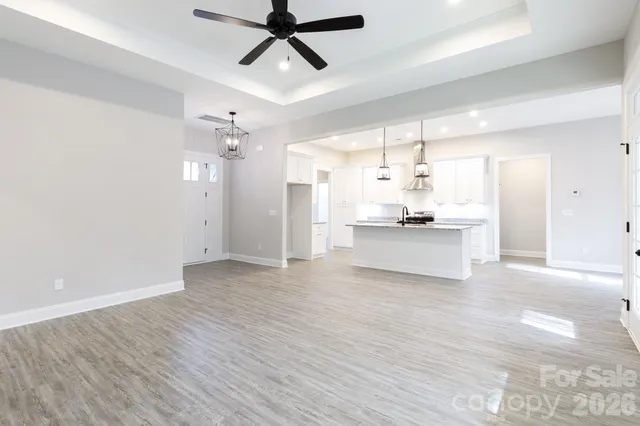 a view of a kitchen with a sink dishwasher a refrigerator with wooden floor