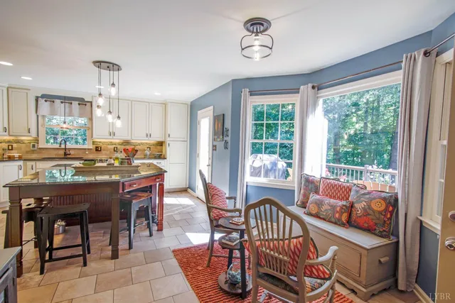 a living room with furniture and painting on the wall next to a window